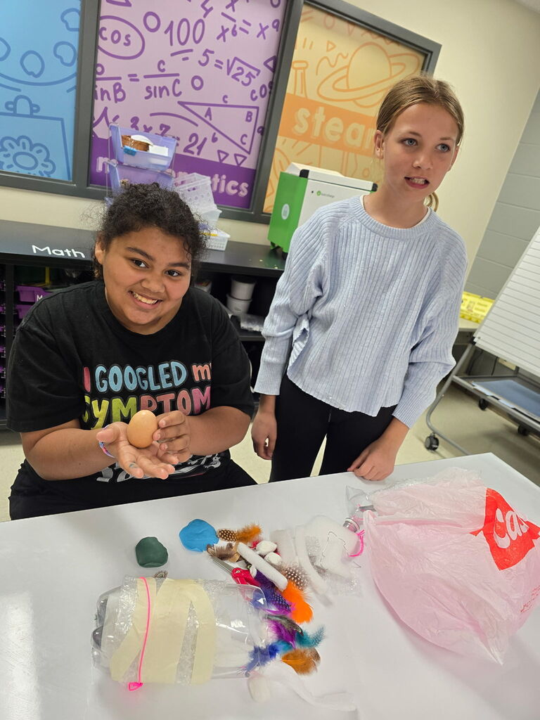 Two students working with an egg.