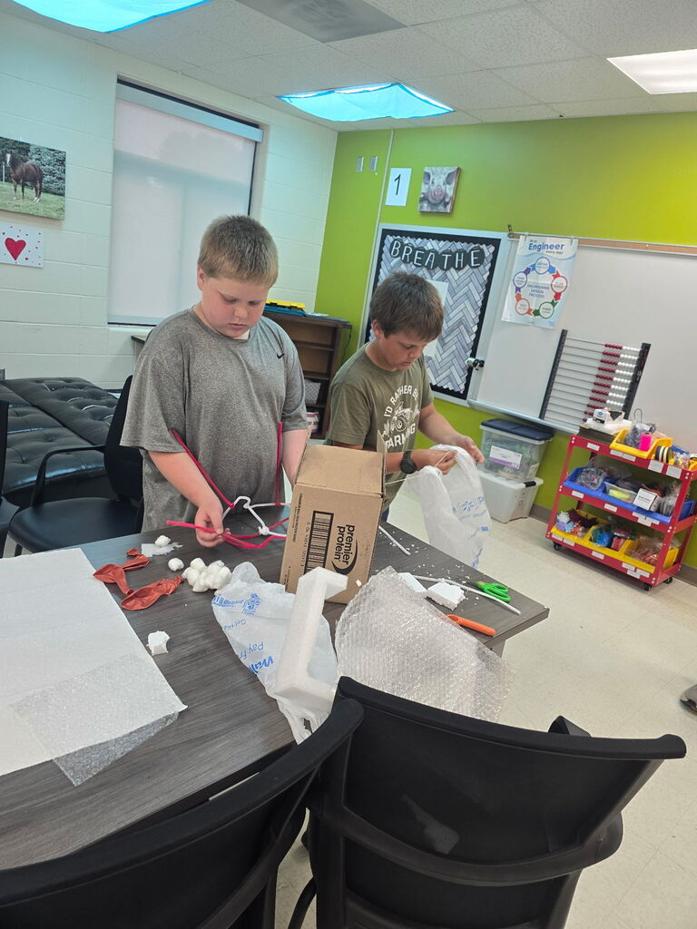 Students working with a box and a bag.