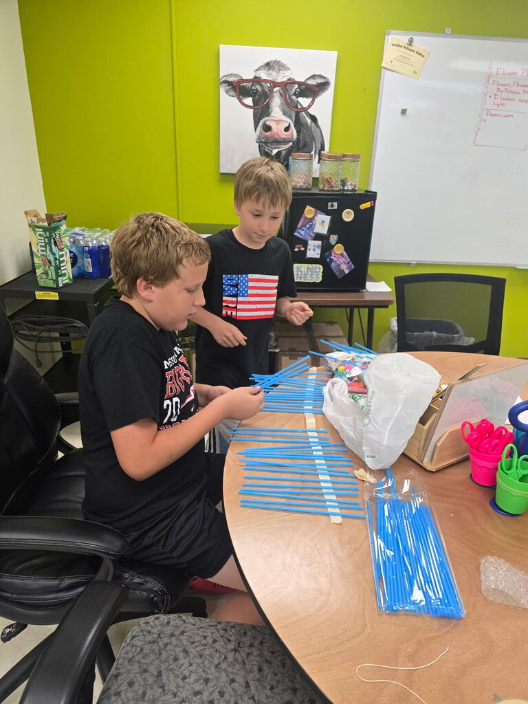 Two students working with blue sticks