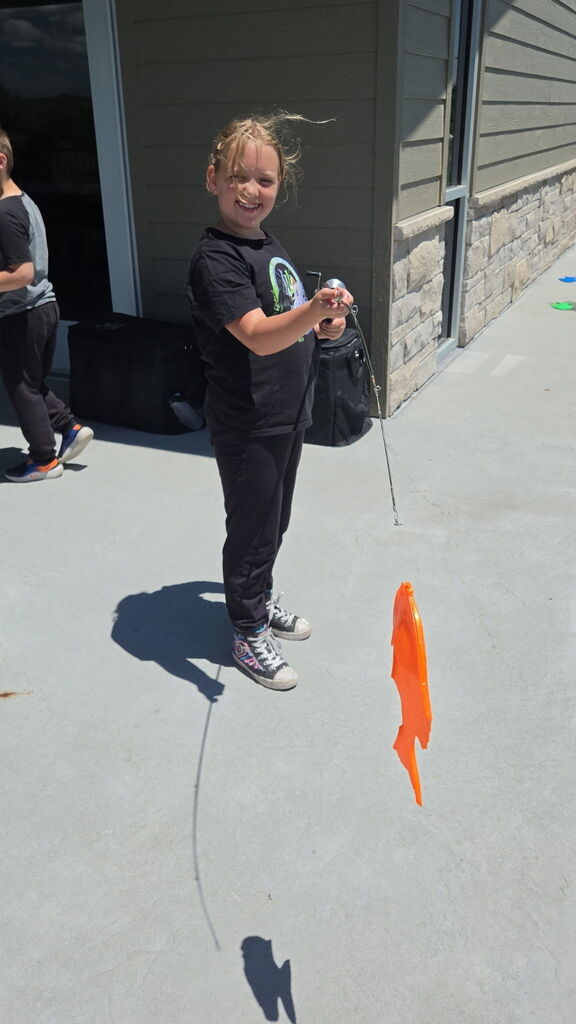 Child holding up an orange fish.