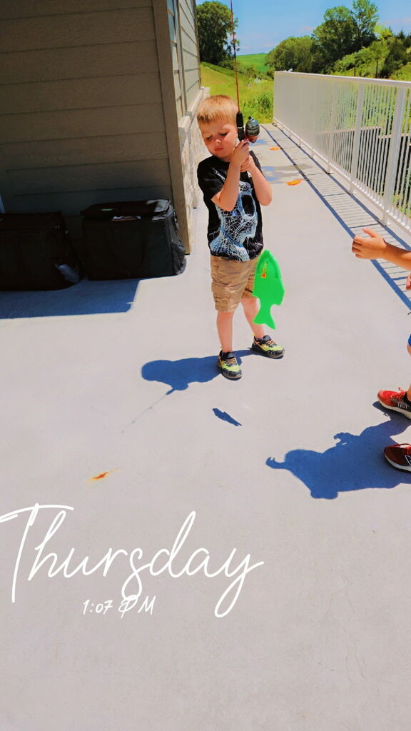 Child holding up a green fish