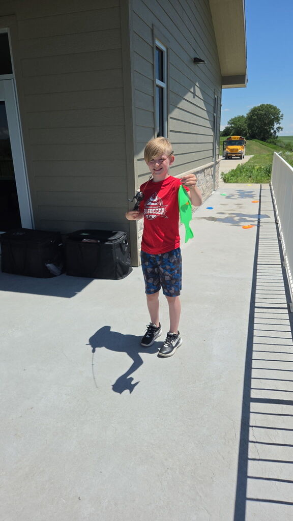 Child holding up a green fish.