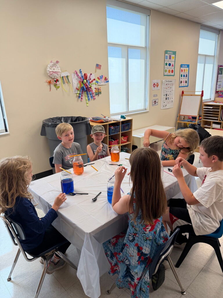 Six kids working at a table.