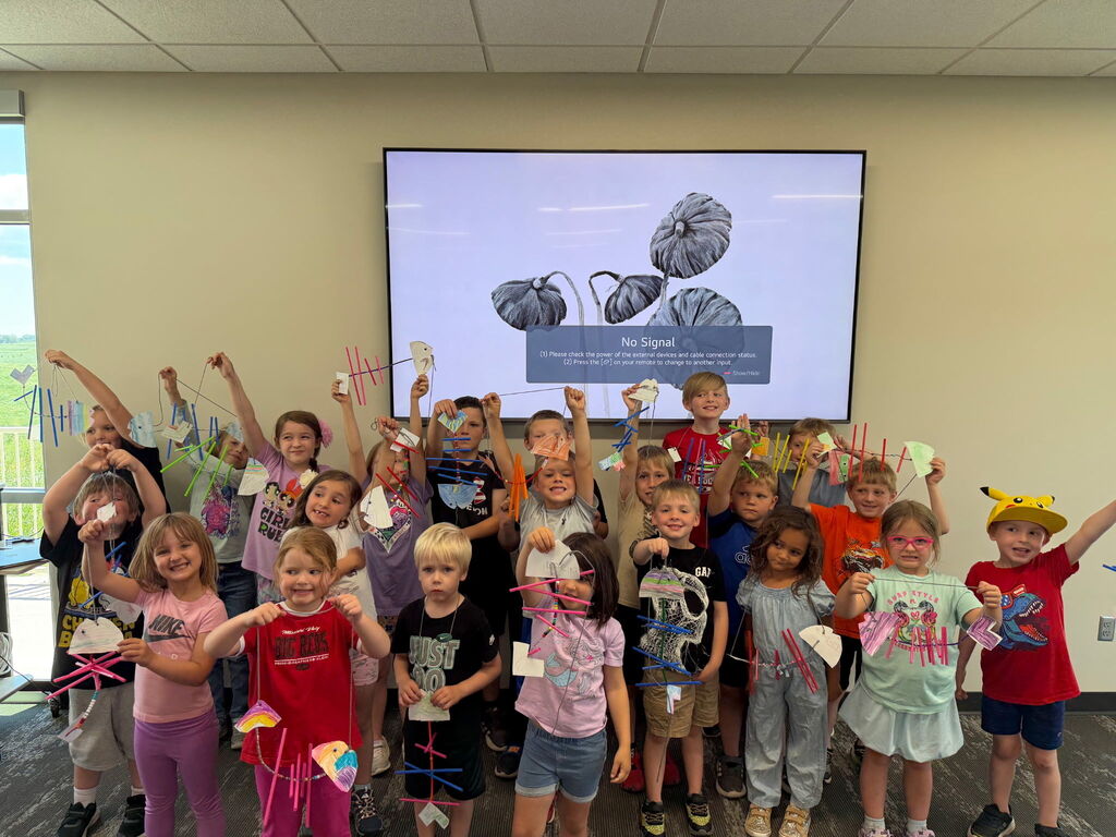 Group of children with their arms in the air.