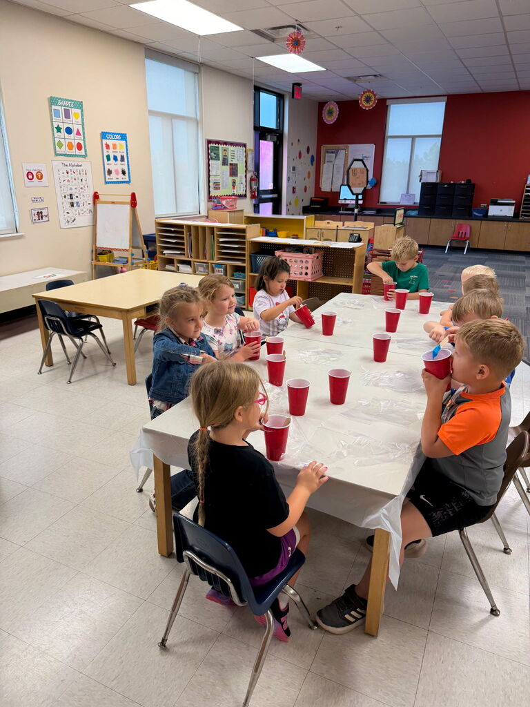 Kids sitting around a table with red cups.