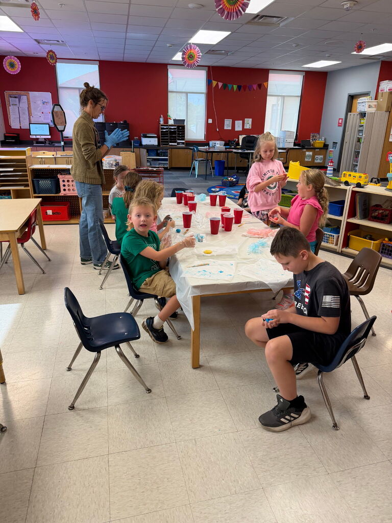 Kids sitting around a table with red cups.