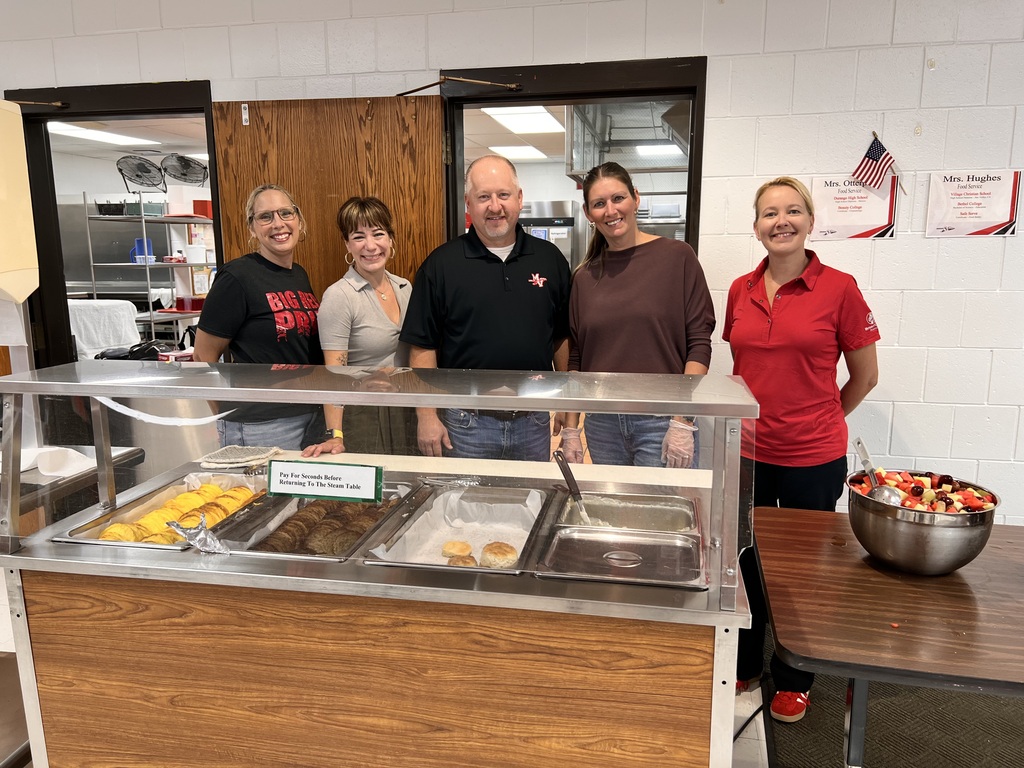 Board members standing behind the food service cart