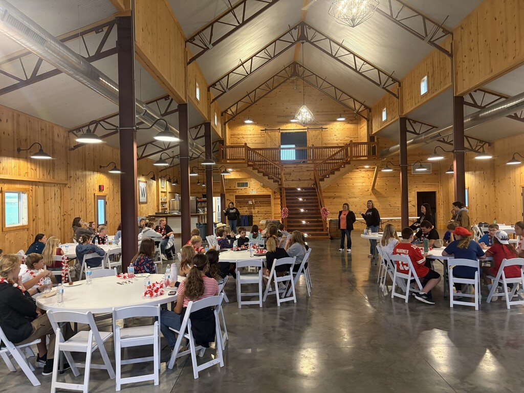 A group of students sitting at round tables.