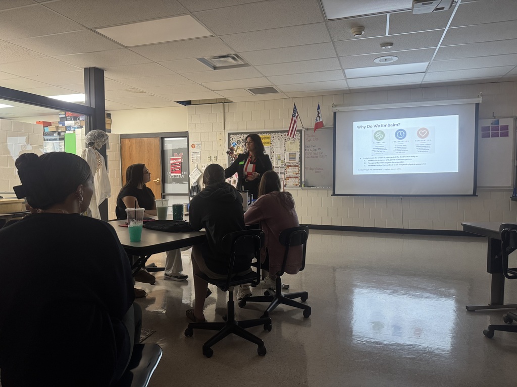 Students listen as a funeral service professional explains the purposes of embalming, including sanitation, preservation, and restoration.