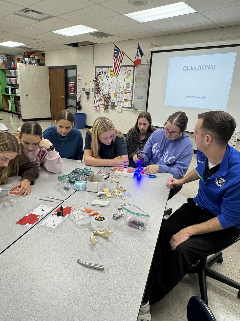 Students explore dental models and tools during a hands-on dentistry demonstration led by a dental professional.
