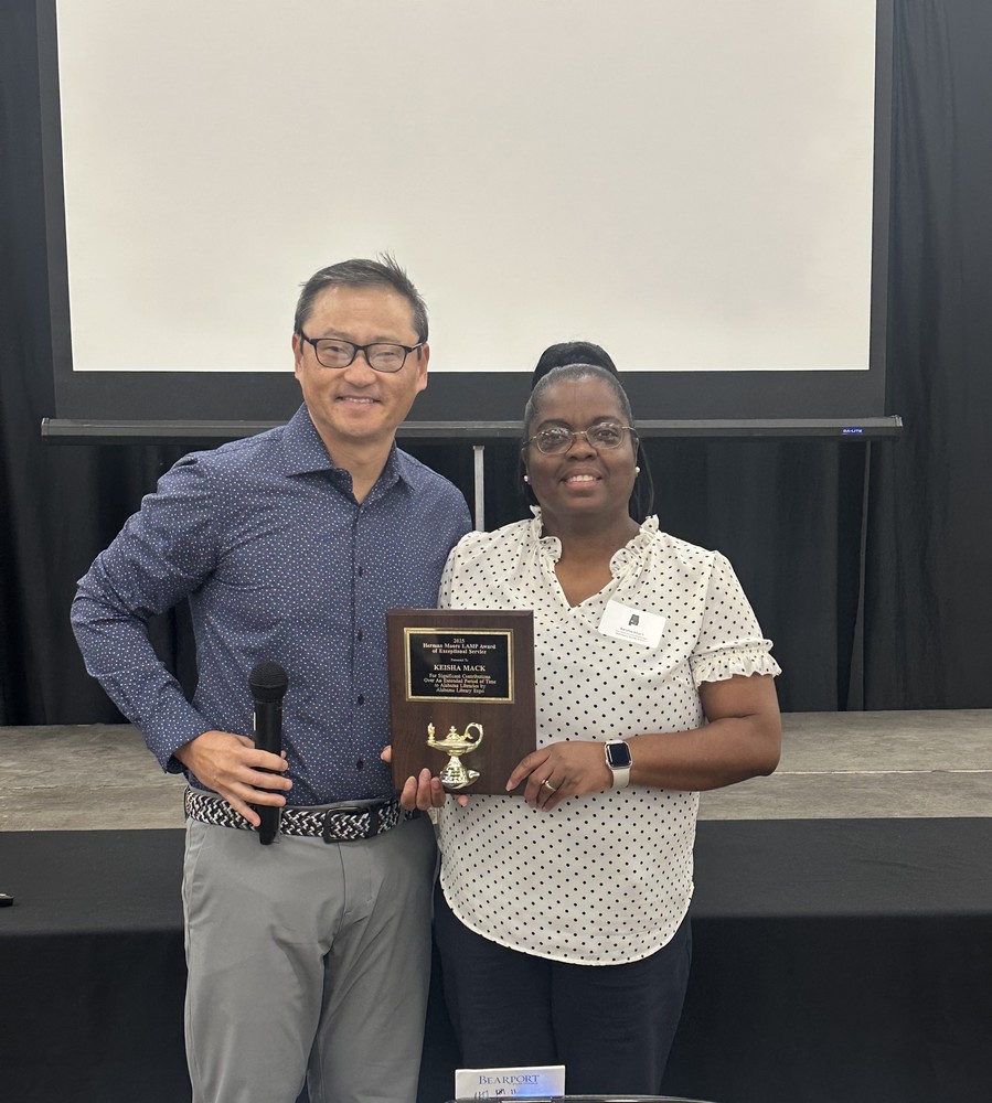 Media Specialist, Mrs. Mack holding her librarian award. Mr. James Taylor, president of Library Expo is also in the picture. 