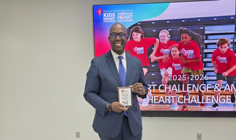MCPSS Assistant Superintendent Terrance Mixon holding a plaque