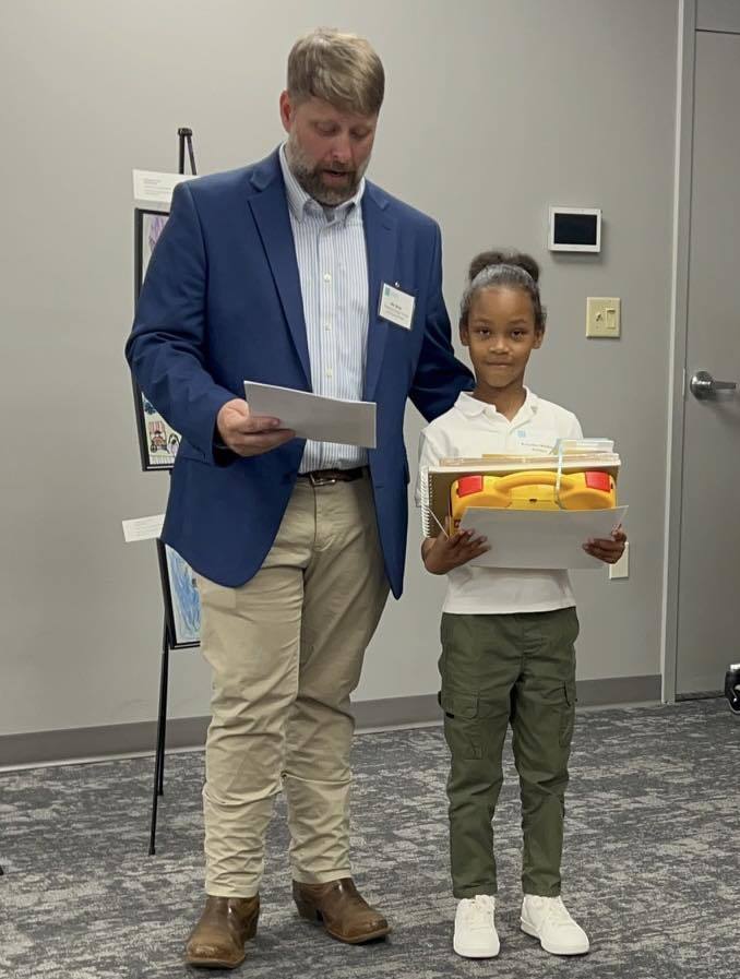 Student receiving award for artwork during dreamARCHITECTURE reception