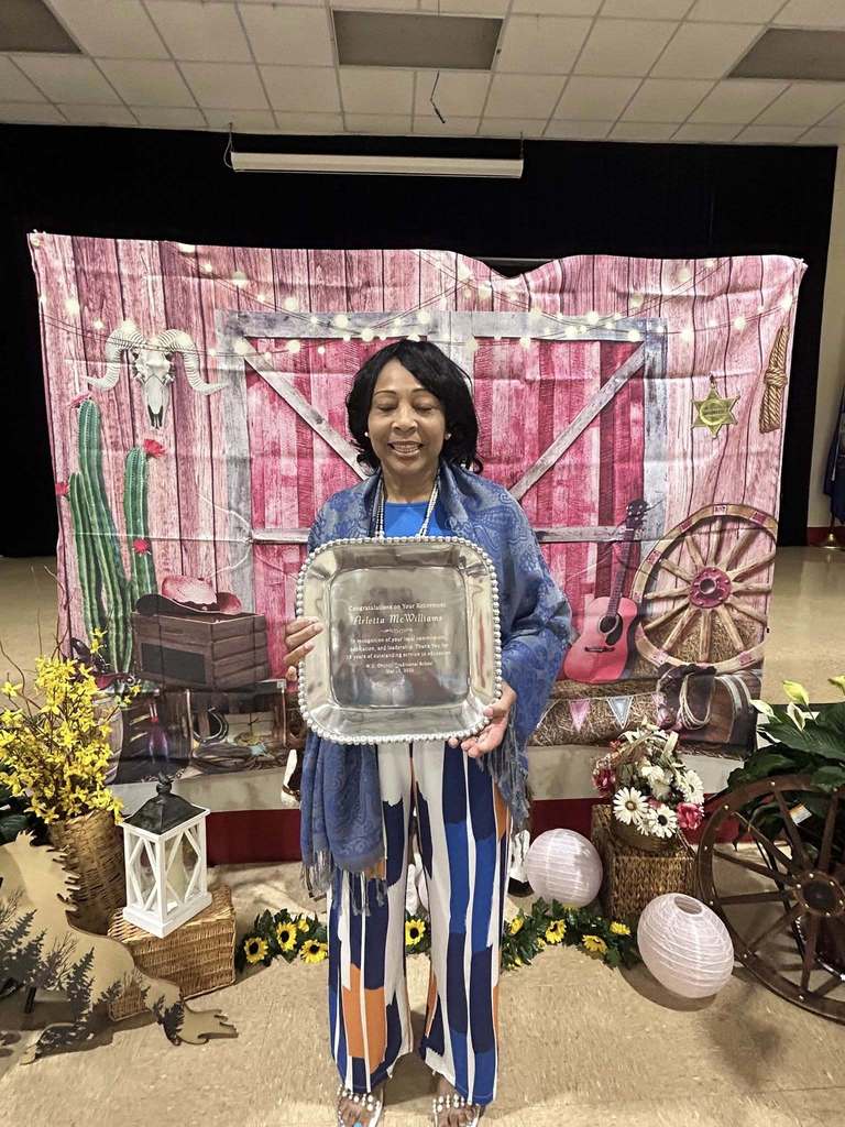 Arletta McWilliams (18 years). holding retirement plaque at retirement celebration