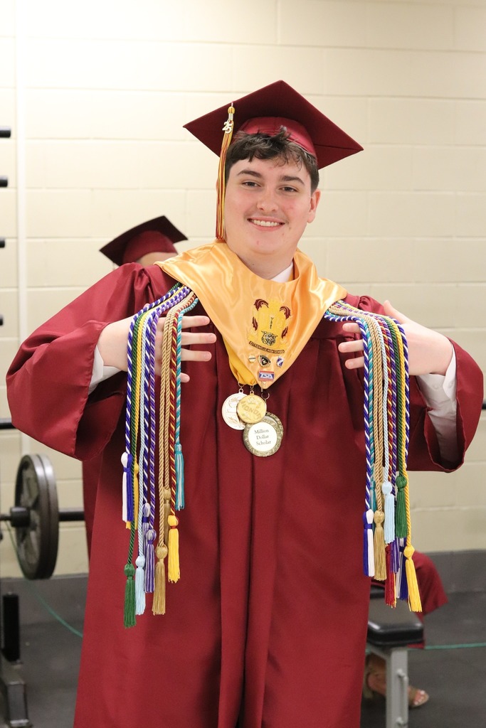 A Citronelle graduate in cap and gown, showing off his cords