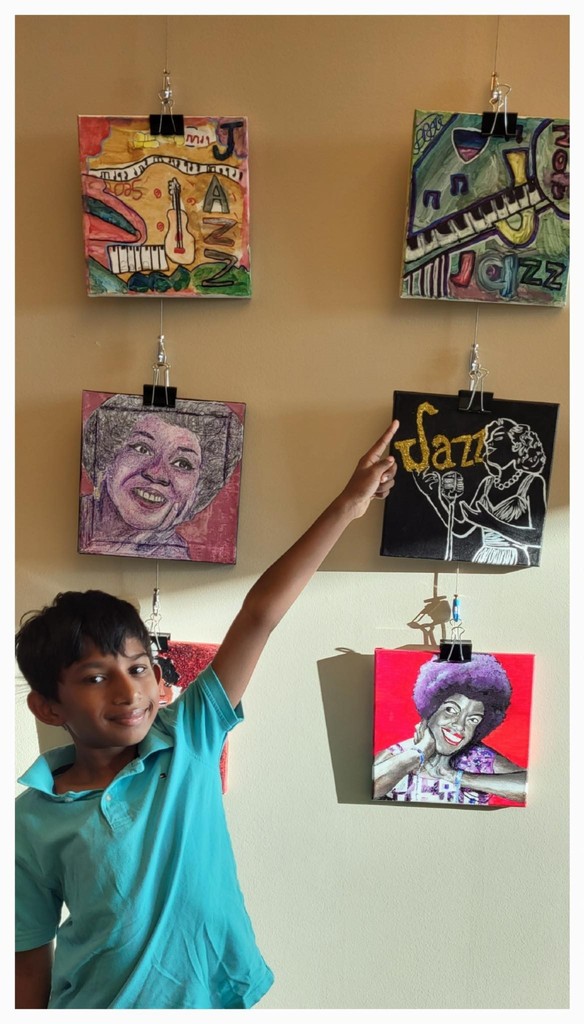 A boy points to artwork with jazz themes