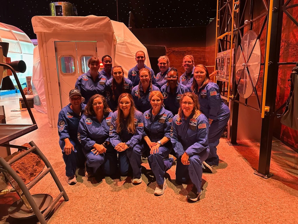 A group of teachers in blue flight suits at the U.S. Space & Rocket Center