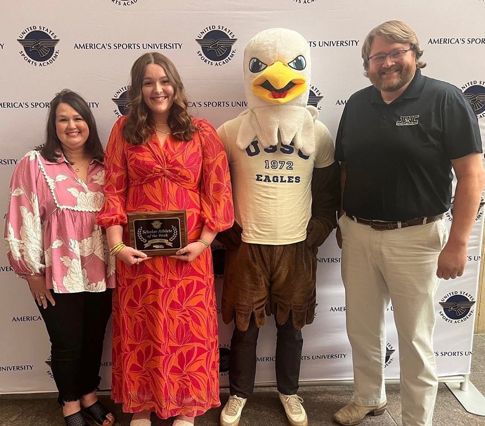 Mary G. Montgomery Clara Heard holds her plaque and is joined by two adults and the US Sports University's eagle mascot