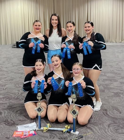 Six dancers holding blue ribbons and their instructor