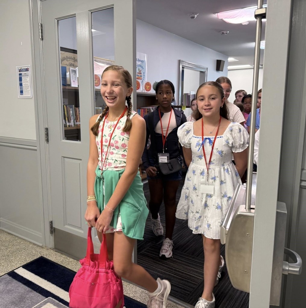 Students in lanyards entering a doorway