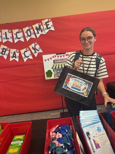 Mrs. Washington, a graduate of Theodore High School, shows her shopping bag for the BCS (Bobcat Supply Company).