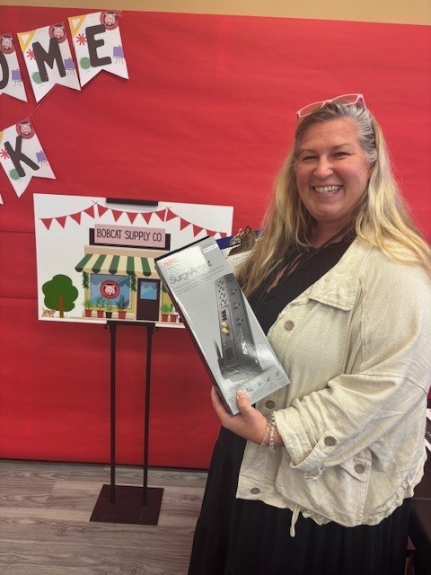 Mrs. Brindza shows off her new surge protector provided by the Bobcat Supply Company!