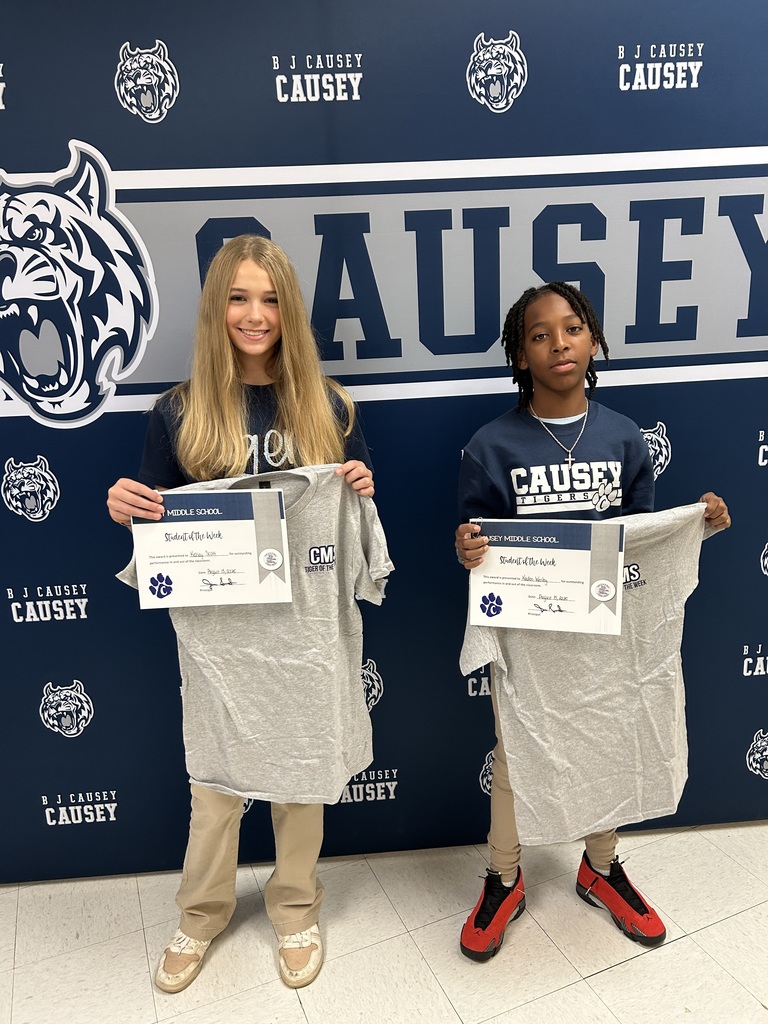 Students holding t-shirts and certificates