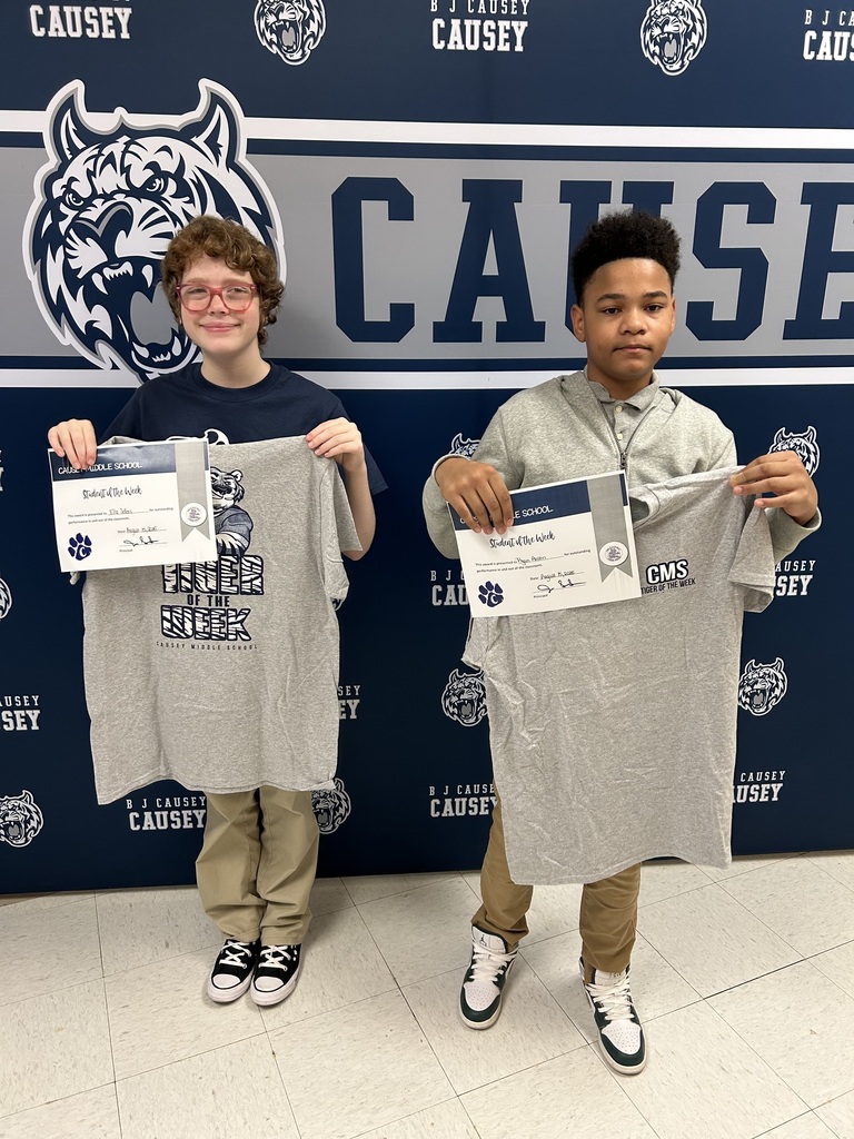 Students holding t-shirts and certificates