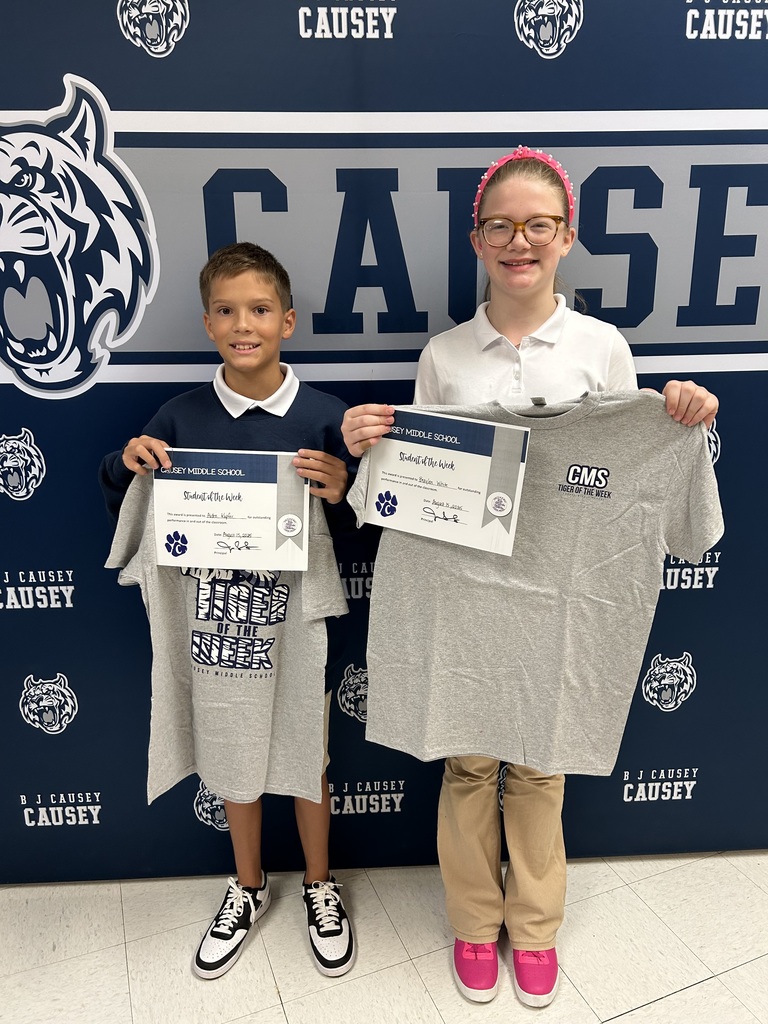 Students holding t-shirts and certificates