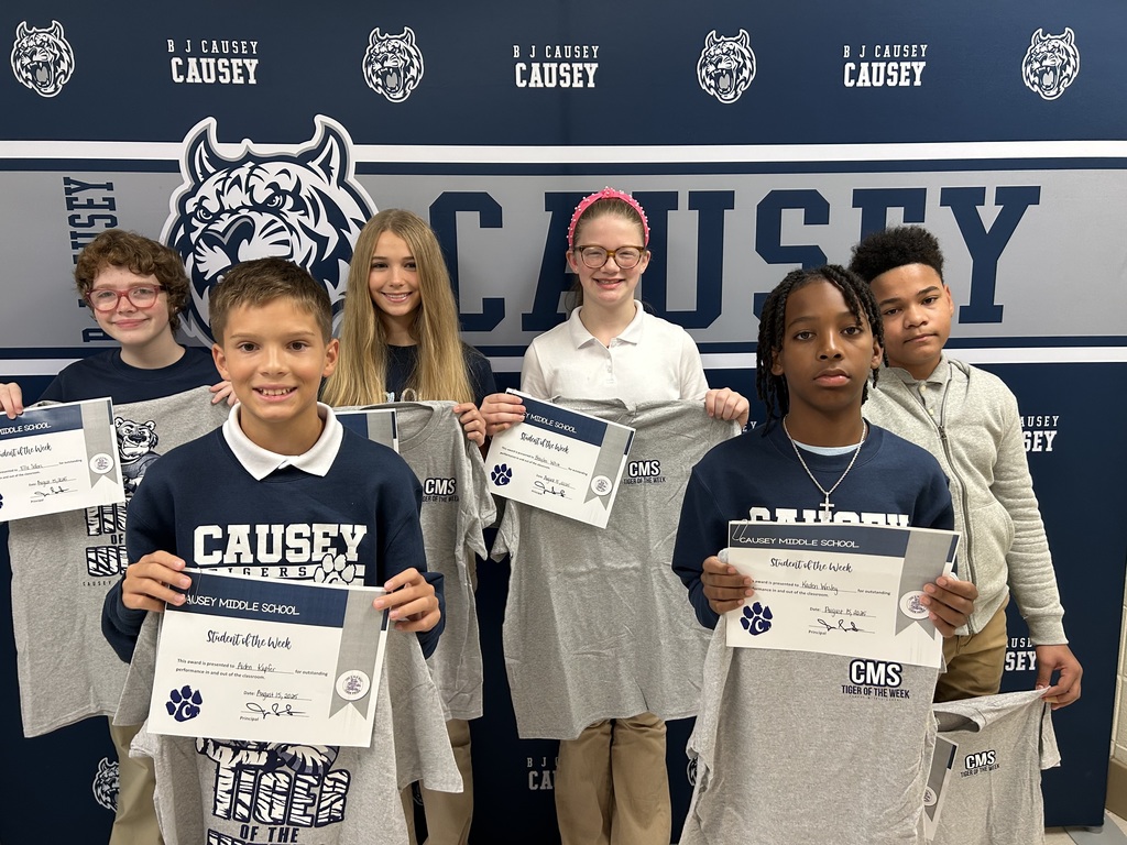 Group of students holding t-shirts and certificate