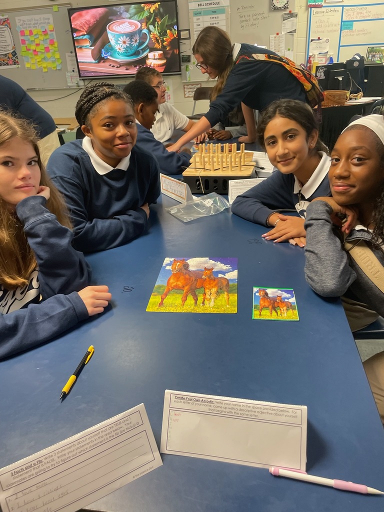 Students at a table in a classroom with some artwork