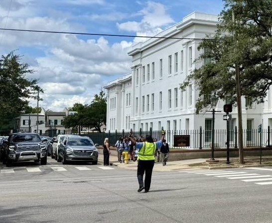 A crossing guard holding traffic in front of Barton Academy