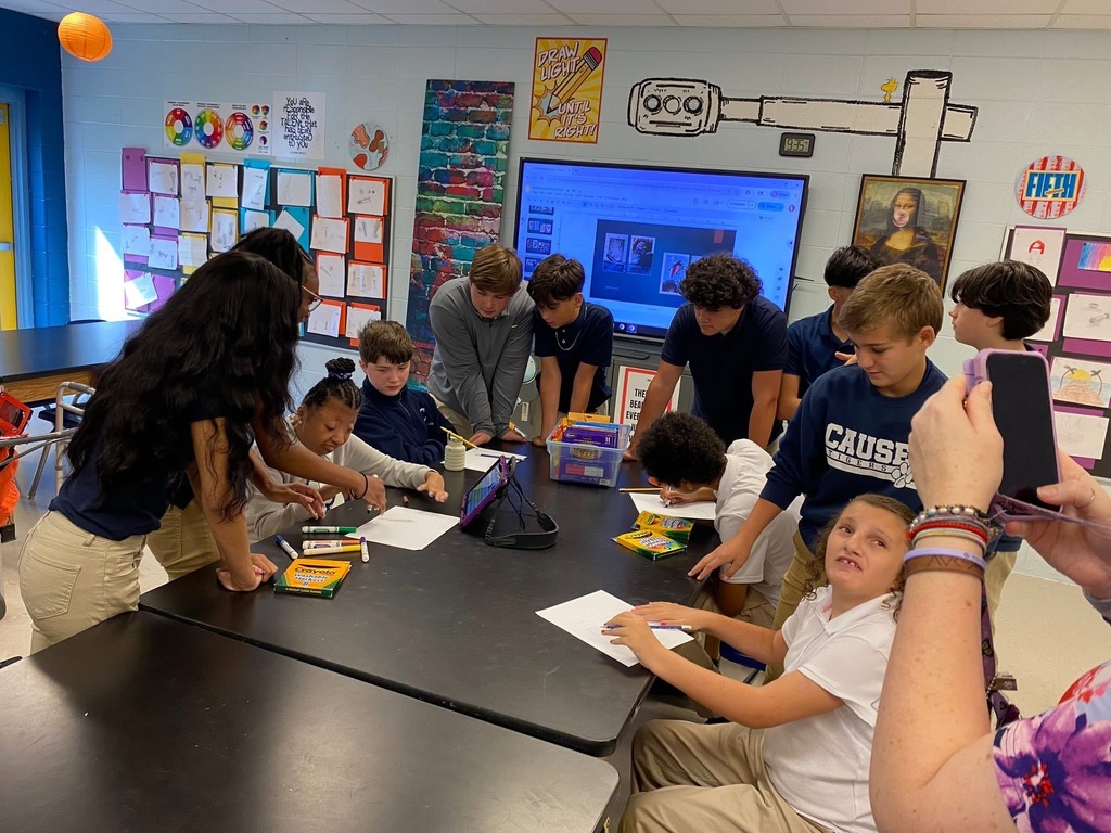Group of students working together, collaborating, peer helping in art class