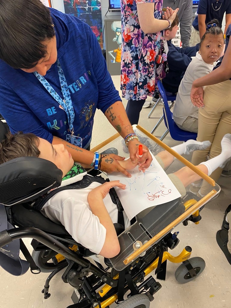 Staff and student in art class, drawing, practicing motor skills