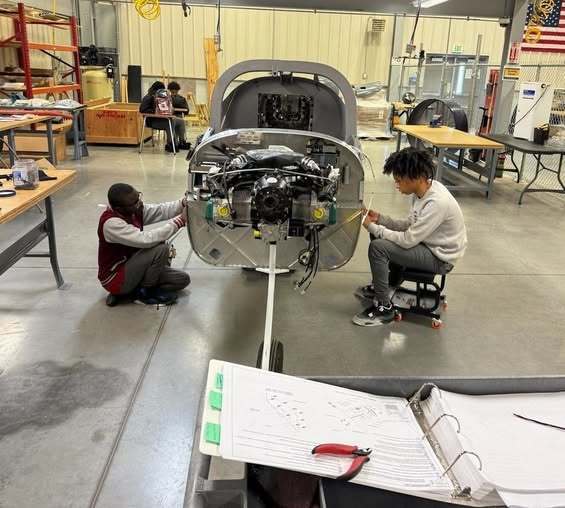 Two students working on an airplane fuselage