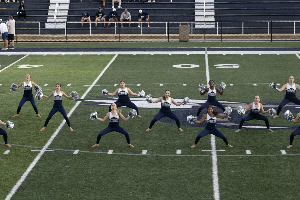 Dance team group of girls on a football field doing a dance