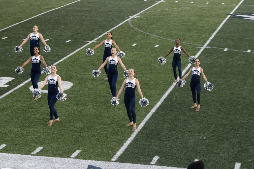 Dance team group of girls on a football field doing a dance