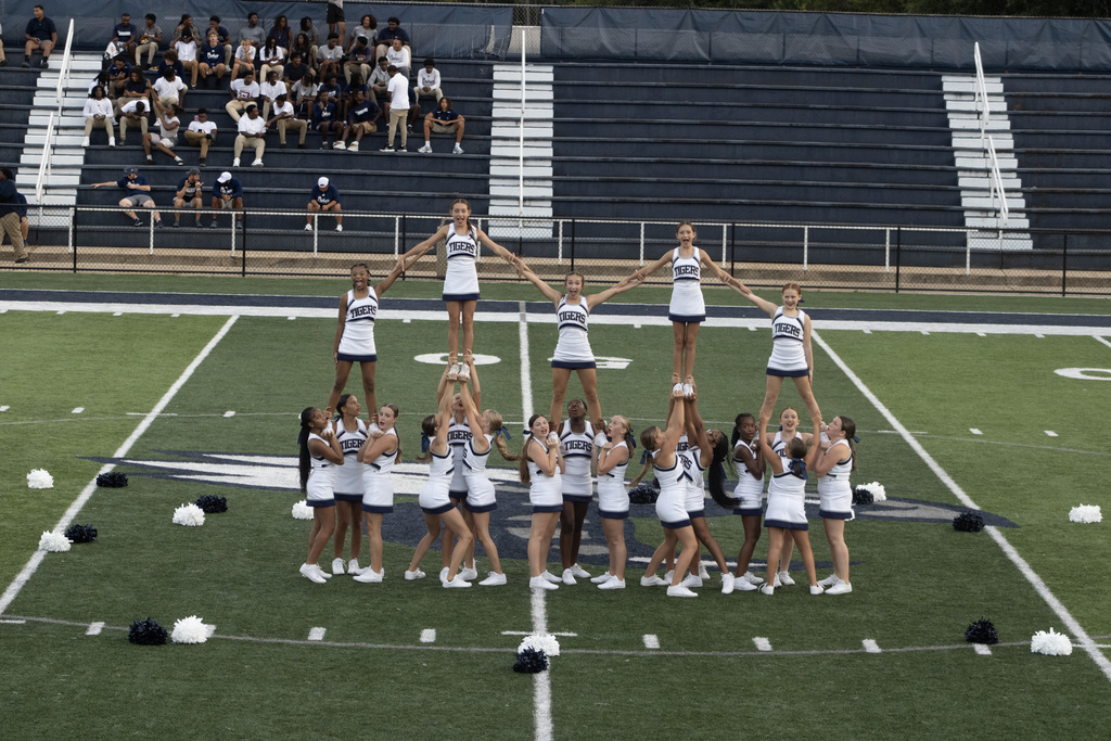 Cheer team on football field doing cheer stunts