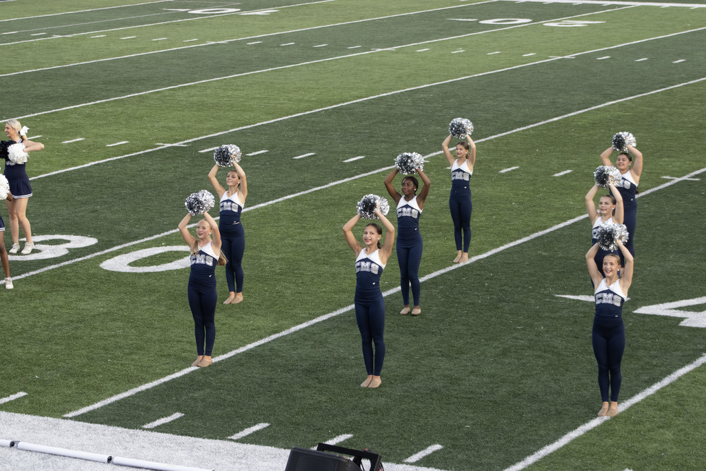 Dance team group of girls on a football field doing a dance