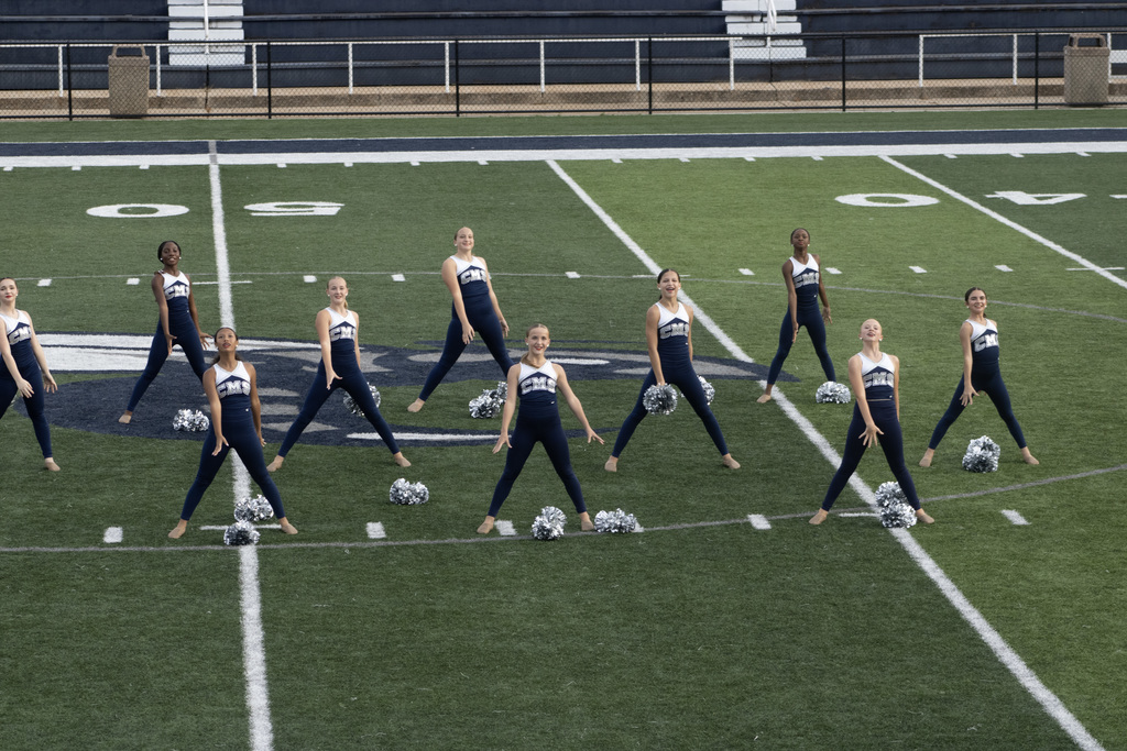 Dance team group of girls on a football field doing a dance