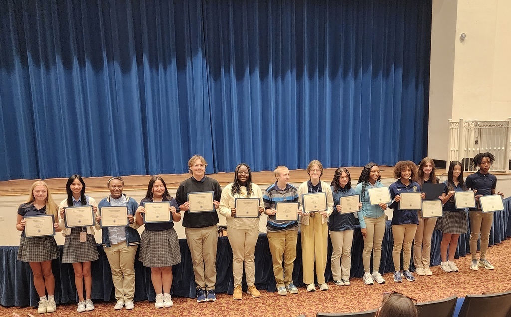A line of students holding certificates