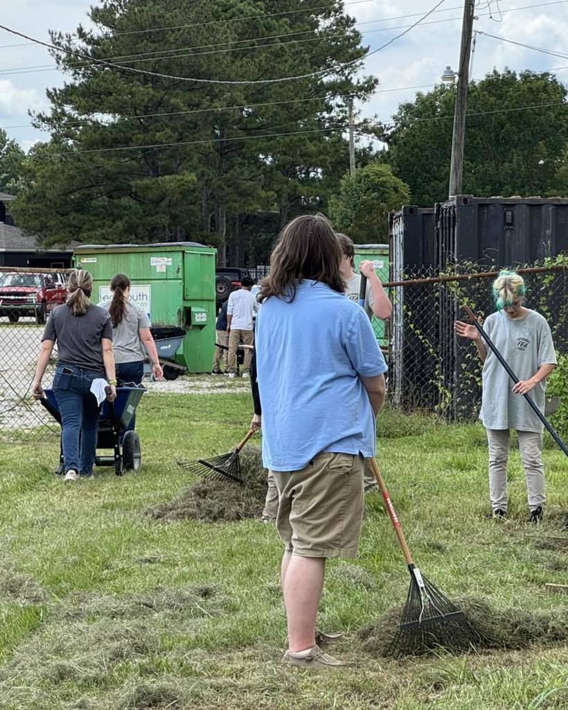 Students raking cut grass