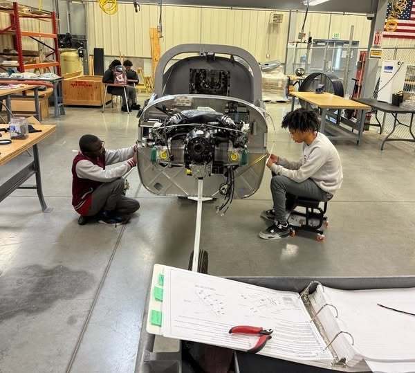 Two people fixing an airplane