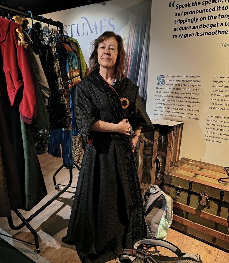 Davidson theater instructor Gloria Poorman trying on a costume backstage