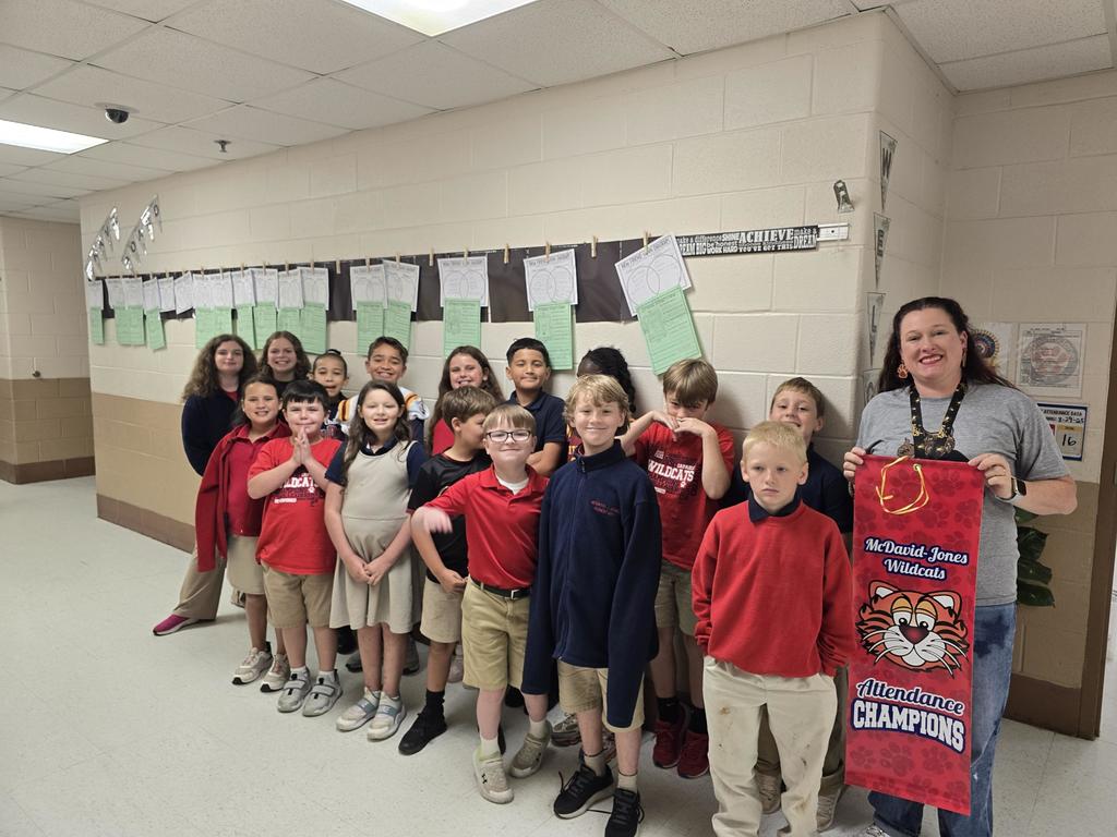 Mrs. Holland's class holding an attendance banner.
