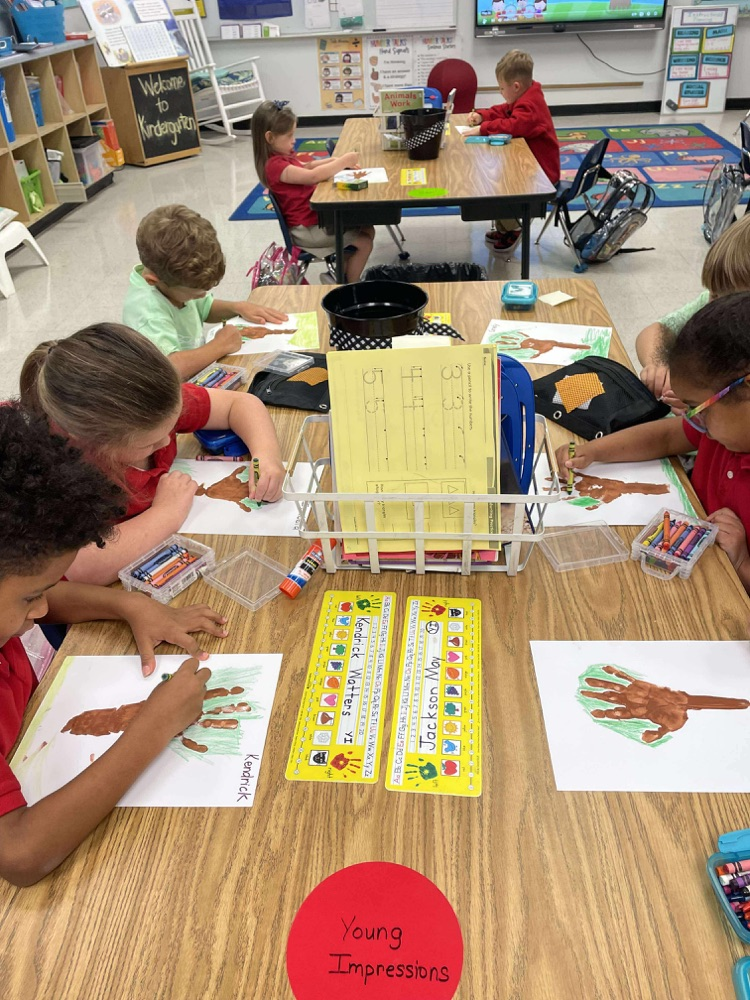 kindergartners working on fall trees adding 10 apples