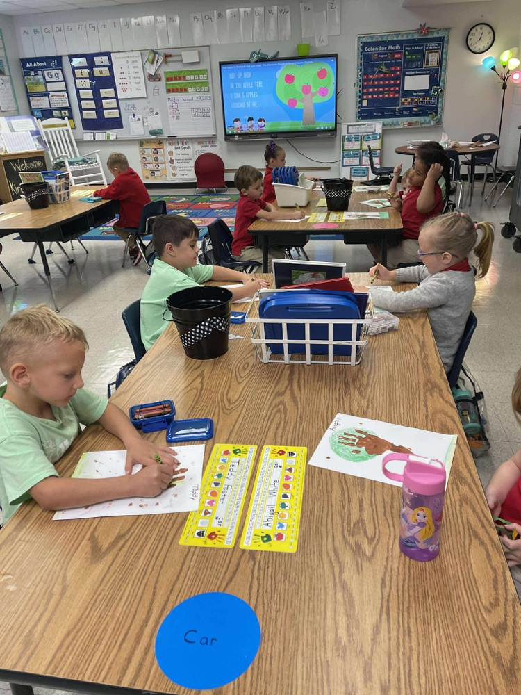 kindergartners working on fall trees adding 10 apples
