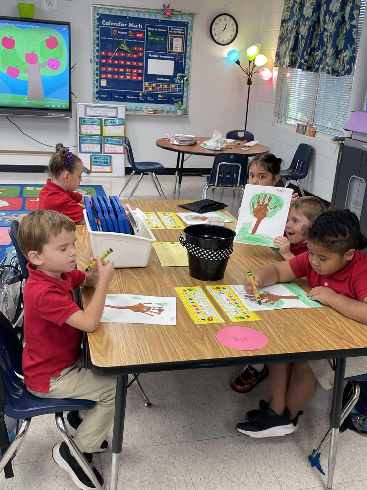 kindergartners working on fall trees adding 10 apples