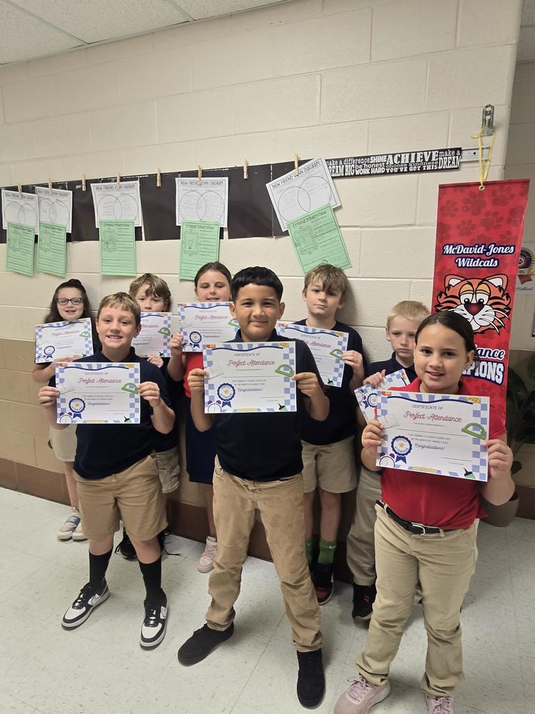 Mrs. Holland's class holding a perfect attendance award for August.