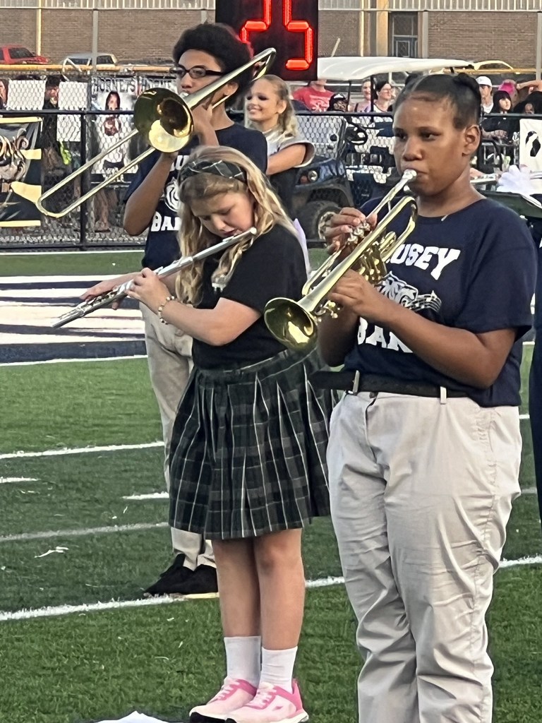 Middle school band members performing on a football field